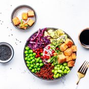 Healthy vegan food. Buddha bowl with quinoa, fried tofu, avocado, edamame, peas, radish, cabbage