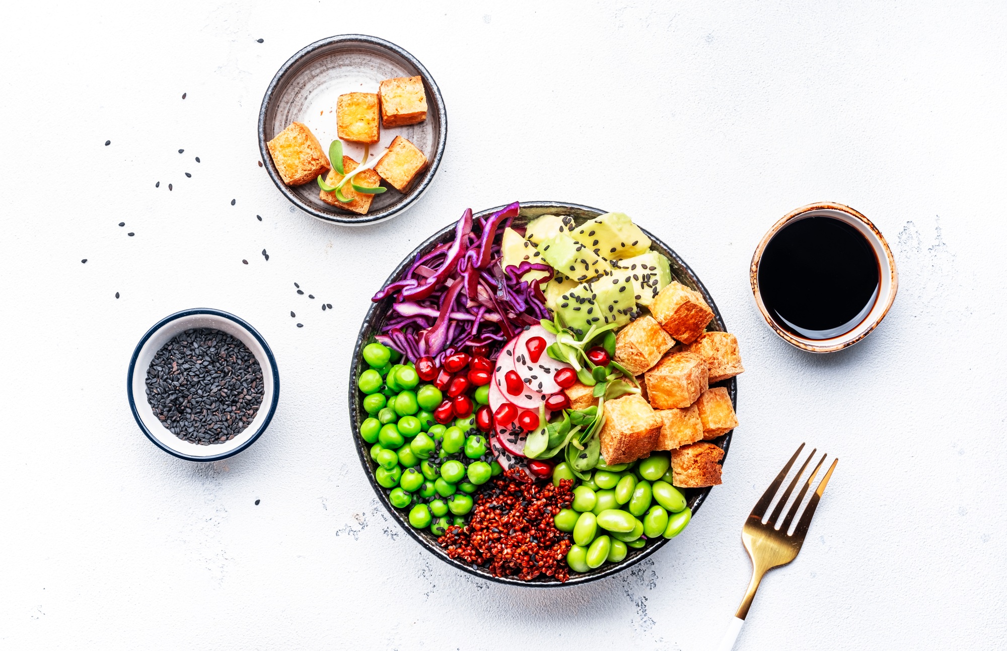 Healthy vegan food. Buddha bowl with quinoa, fried tofu, avocado, edamame, peas, radish, cabbage